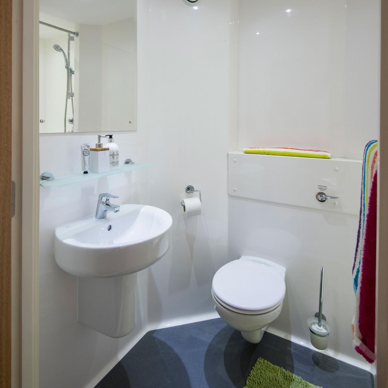 Toilet and wash basin with mirror in a bright, modern bathroom.