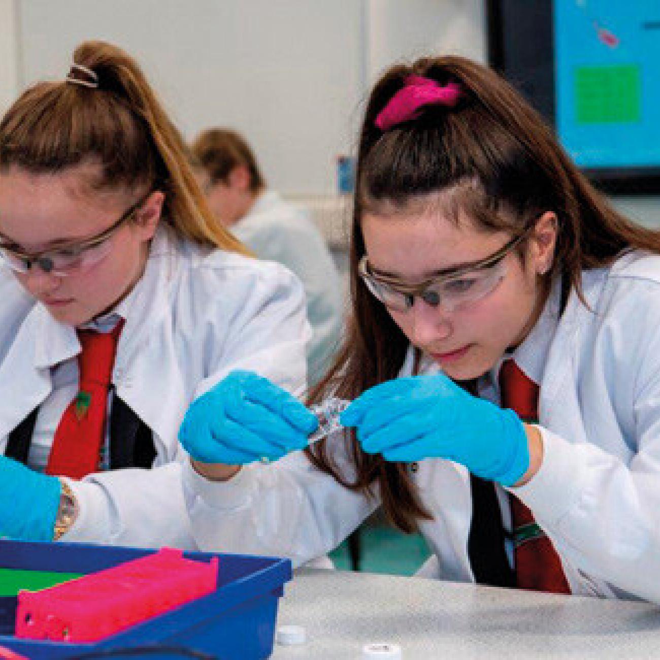 Two school students taking part in a science experiment at their desks, as part of the LifeLab programme.