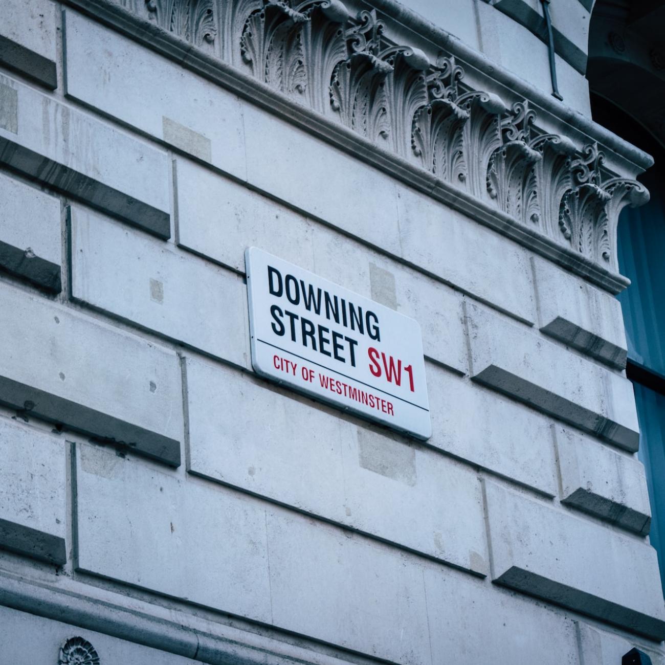 A sign on a white neo-classical building says Downing Street, which is where the UK Prime Minister and Government departments are based