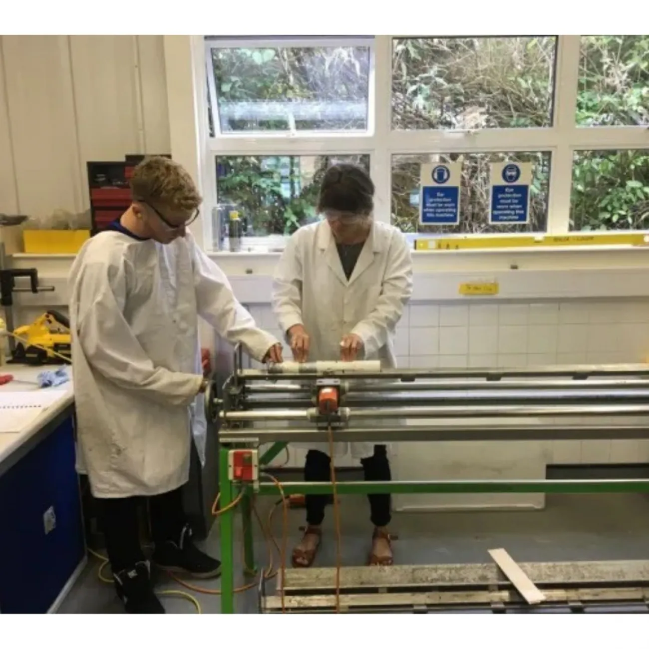 Two researchers splitting a deposits core