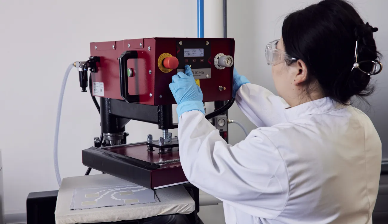 A woman researcher using a machine at the e-textile laboratory