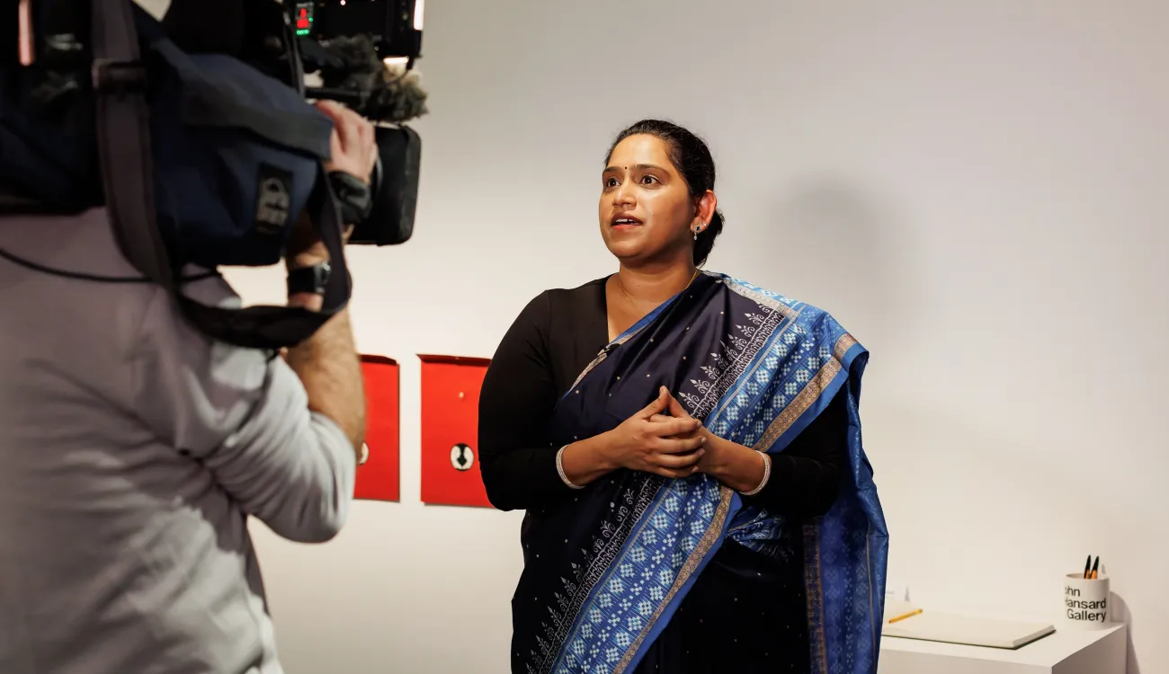 A camera person films Priti Mishra