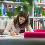 Student writing at desk