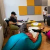 Group of students in common room, sat talking and playing pool.