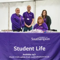 Members of the 24/7 halls support team in uniform behind a table. 