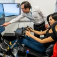 Female aerospace student with teach giving demonstration on simulator