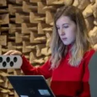 Female undergraduate acoustical engineering student testing equipment