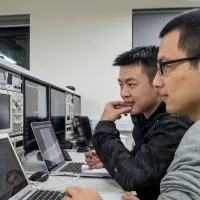 Two male computer science students sitting and looking into their computer