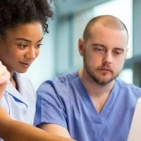 three health and social care workers looking at a computer screen