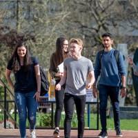 five international law students walking through campus