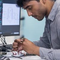 Male mobile secure system engineering student holding an electronic device