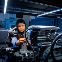 A mechanical engineering student uses a piece of complex machinery