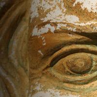 Close up of an ancient artefact face carved in stone