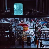 An optical table with components such as lasers, tapered amplifiers, optical fibers and various free-space optics and optomechanics. 