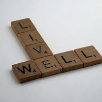 Wooden Scrabble pieces spelling out the words Live Well