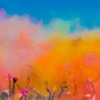 Group of people throwing coloured powder in the air