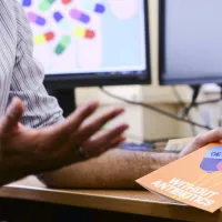 A hand holding a get well without antibiotics card