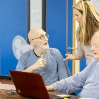 2 men using a laptop together