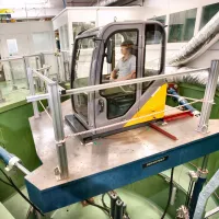 Research participant seated within a six-degree-of-freedom motion simulator in a laboratory