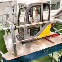 Person operating an excavator cab simulator on a motion platform in the Vibration and Simulation Laboratory