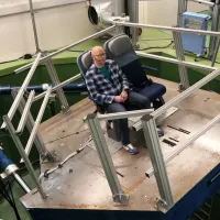 Six-axis motion simulator with aircraft-style seating used for vibration and motion research in the VibSim laboratory